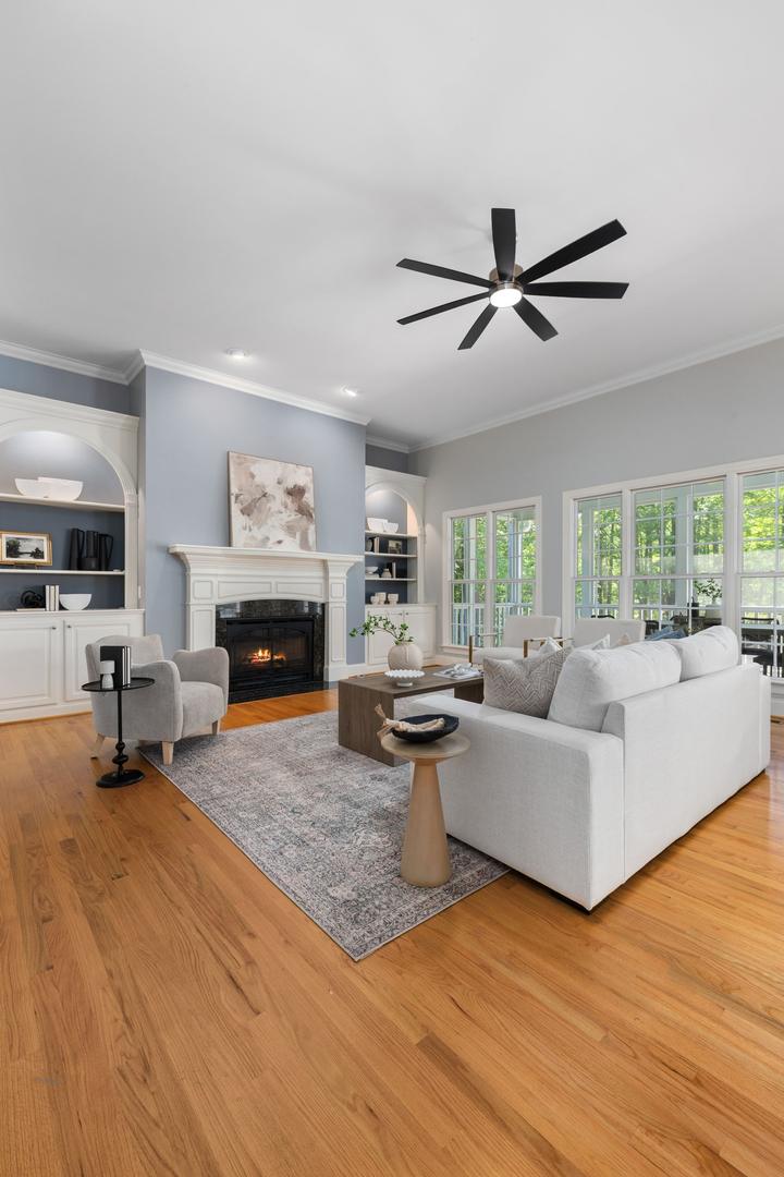Fireplace beside gray seating and a wide window